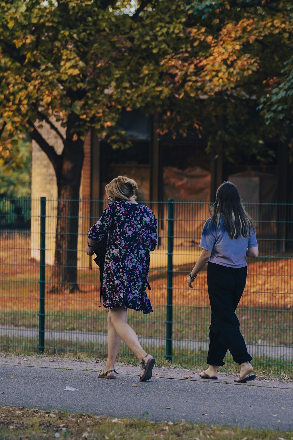 two women walking on a sidewalk