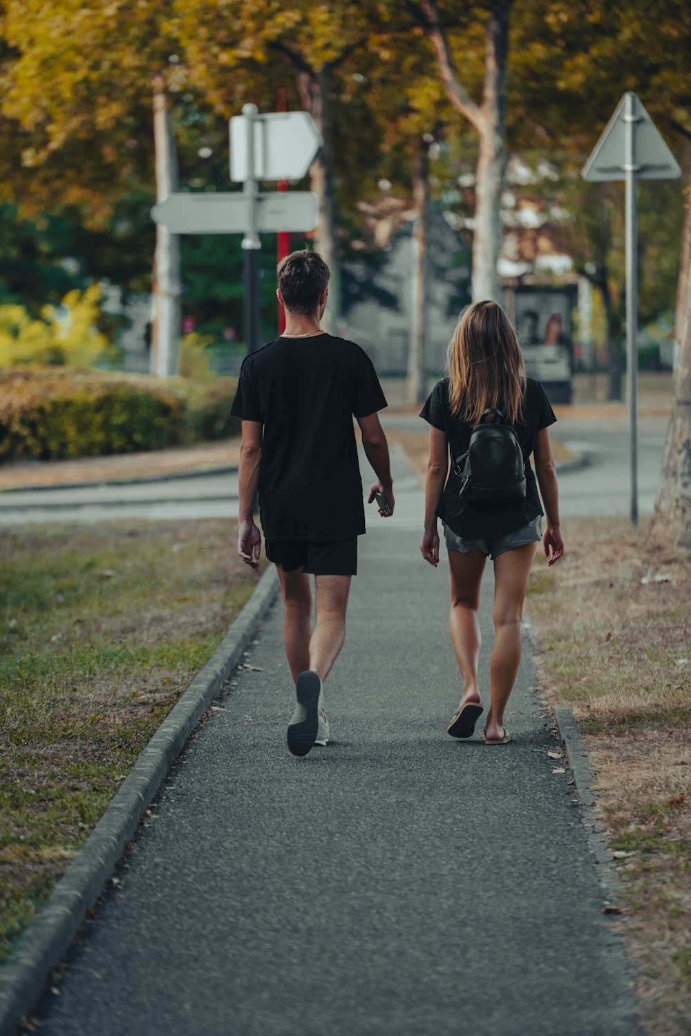 a man and woman walking down a sidewalk