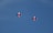 Two red jets fly in formation against a clear blue sky, exhibiting sleek aerodynamic designs.