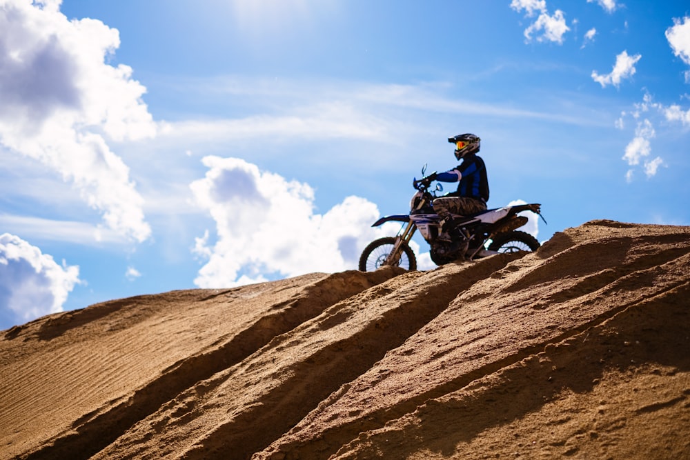 a man riding a dirt bike on a dirt hill