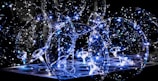 Transparent balloons filled with tiny, twinkling LED lights create a mesmerizing and festive atmosphere. The illuminated strands of lights inside the balloons give a magical and ethereal effect against a dark background.