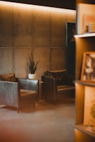 A minimalist seating area with black leather chairs and subtle grey accents.