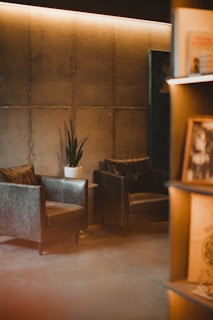A minimalist seating area with black leather chairs and subtle grey accents.