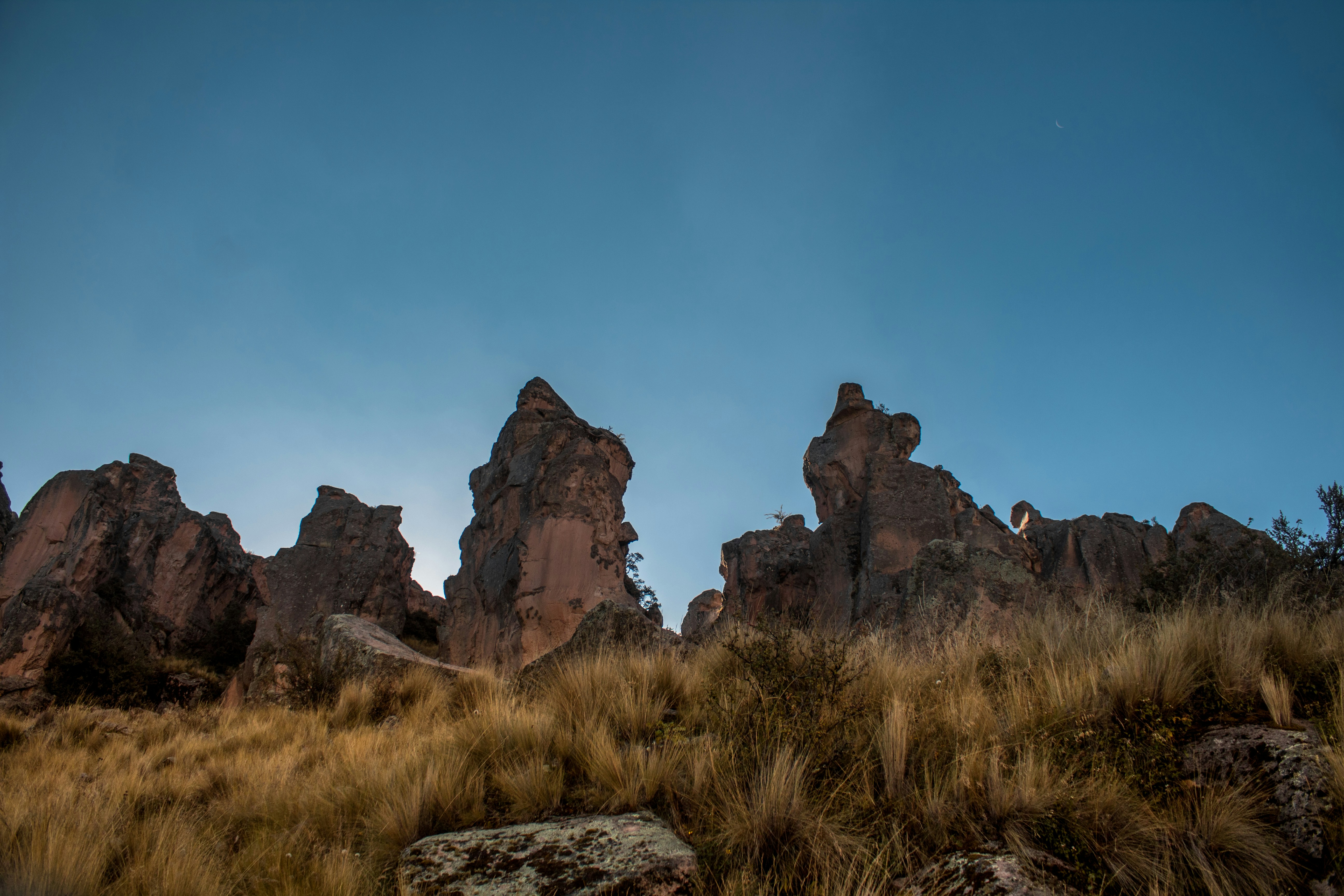 A group of tall rocks in a grassy area photo – Free Perú Image on Unsplash