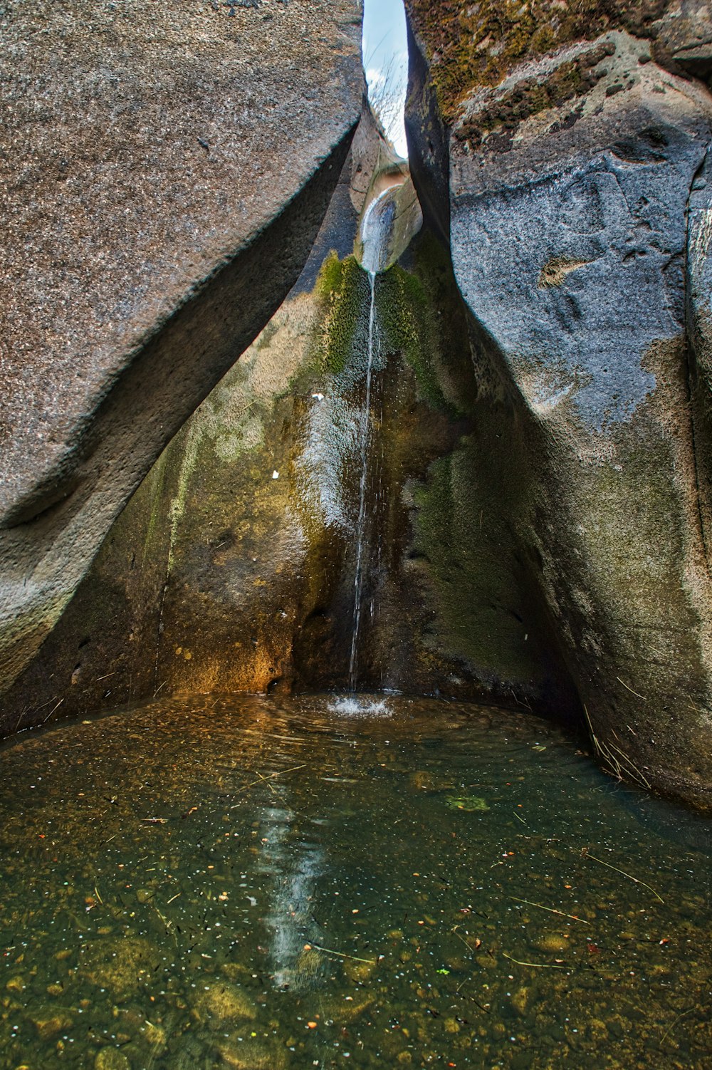 a water fall with a rock wall