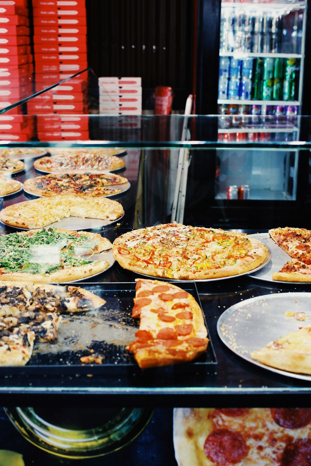 a display case with pizzas