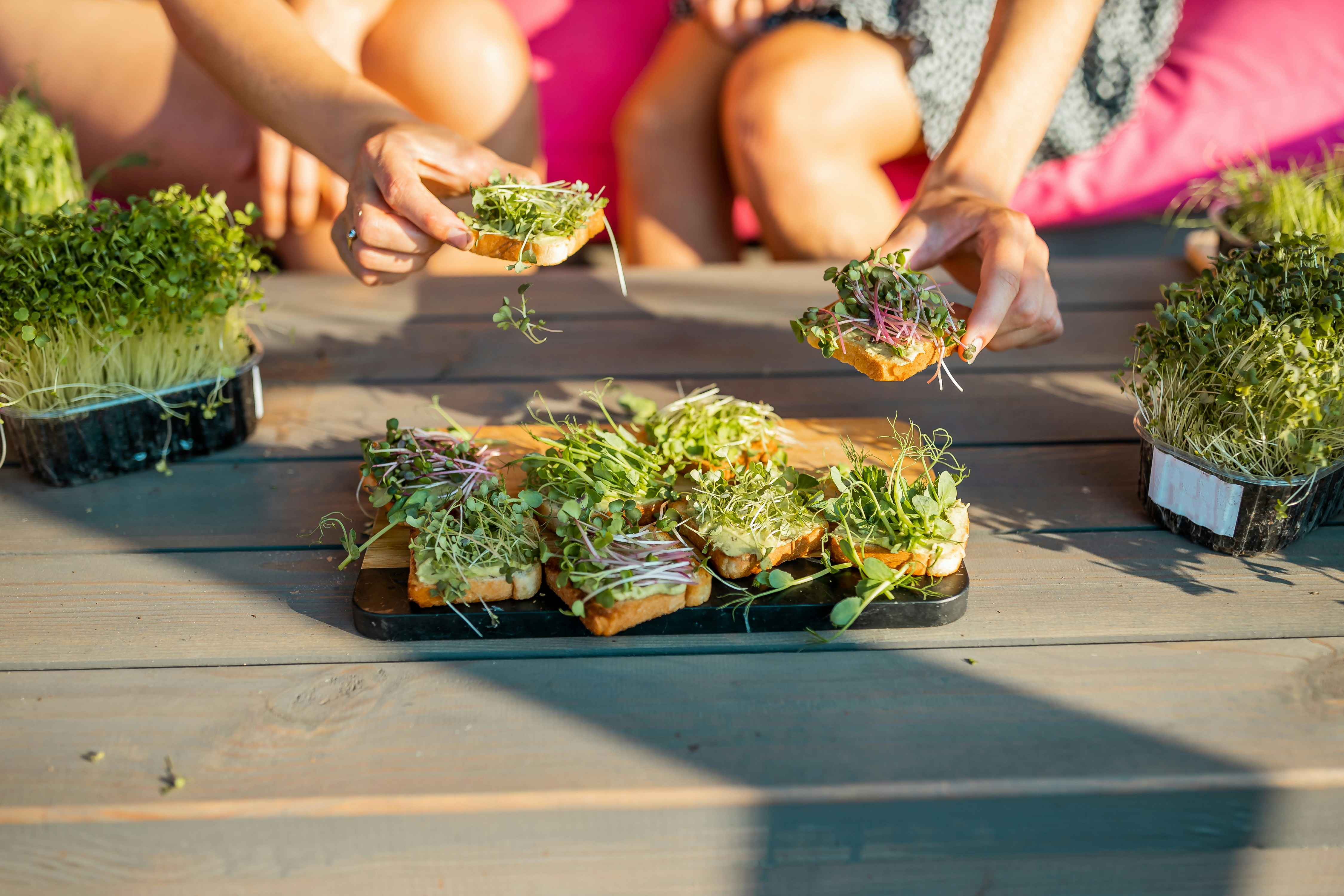 a group of people sitting at a table with plants