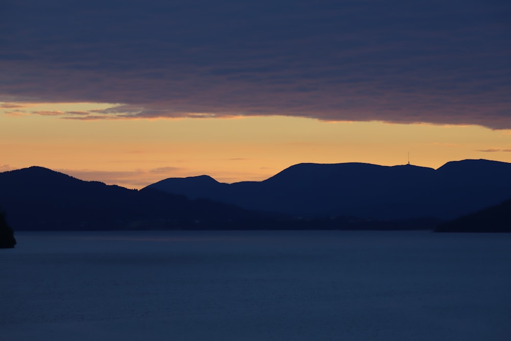 a body of water with mountains in the background