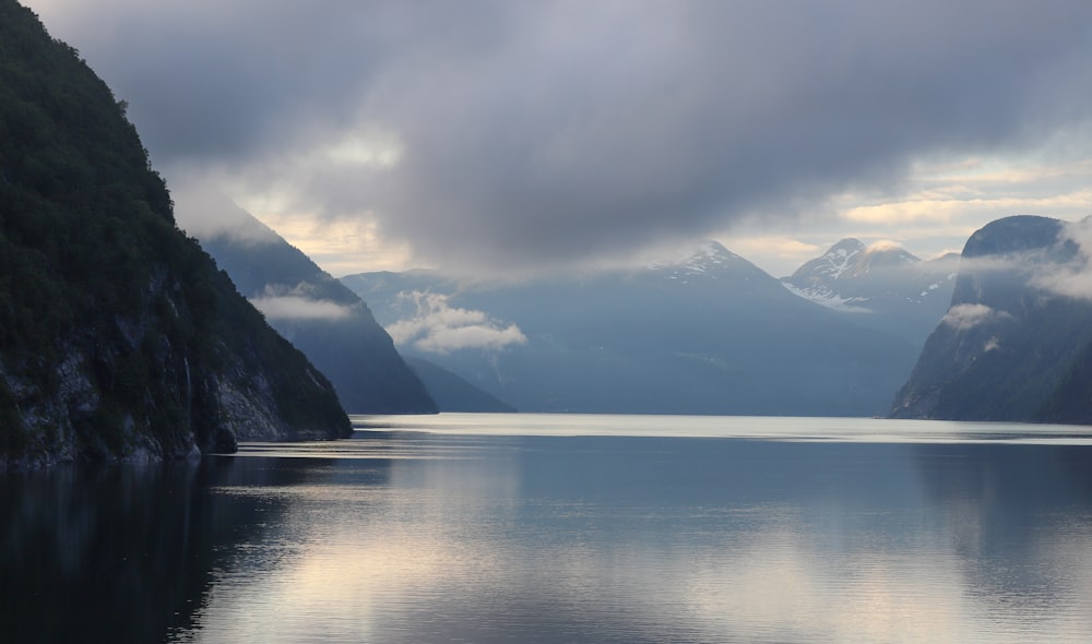 a body of water with mountains in the back