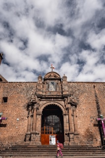 a girl standing on stairs outside a building with a cross on top