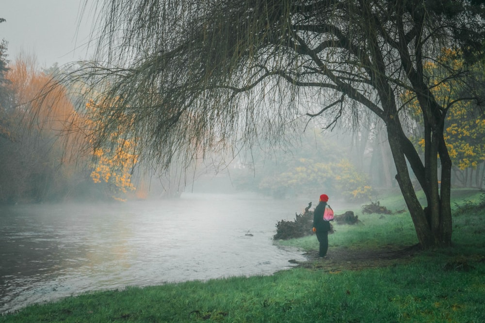 a person standing next to a tree