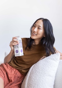 Close-up of a smiling customer holding a package from aquitemshop in a cozy home setting.