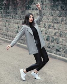 A model wearing a sleek black leather coat standing against a stormy sky, embodying power and style.