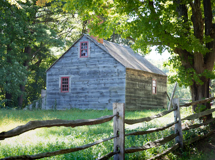 Weathered wood farmhouse with a split rail fence
