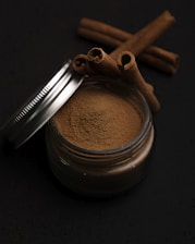 a metal cup with a brown substance and a metal spoon