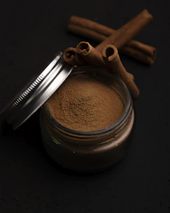 a metal cup with a brown substance and a metal spoon