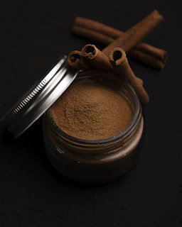 a metal cup with a brown substance and a metal spoon