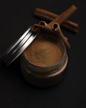 a metal cup with a brown substance and a metal spoon