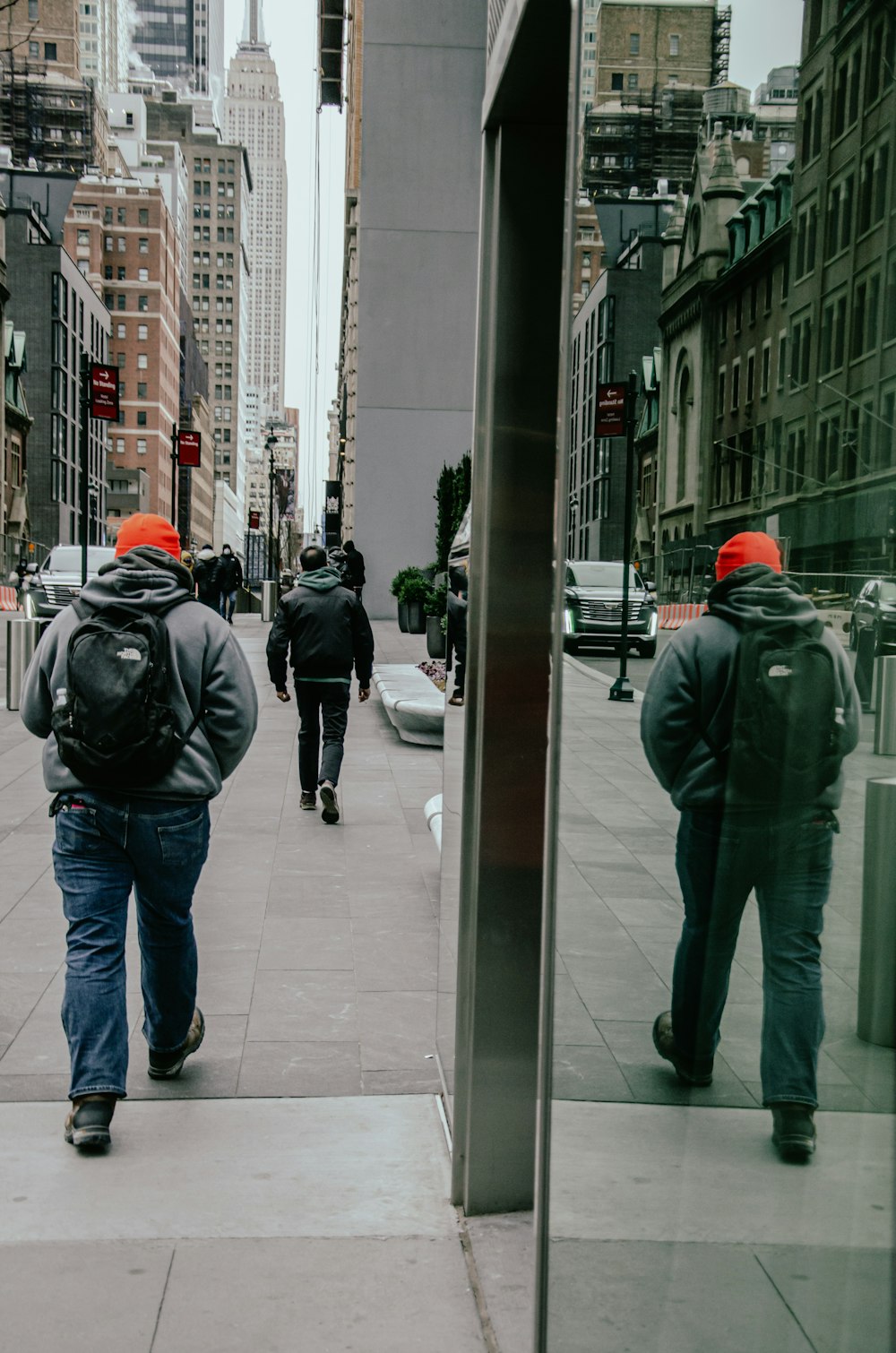 a group of people walking down a sidewalk