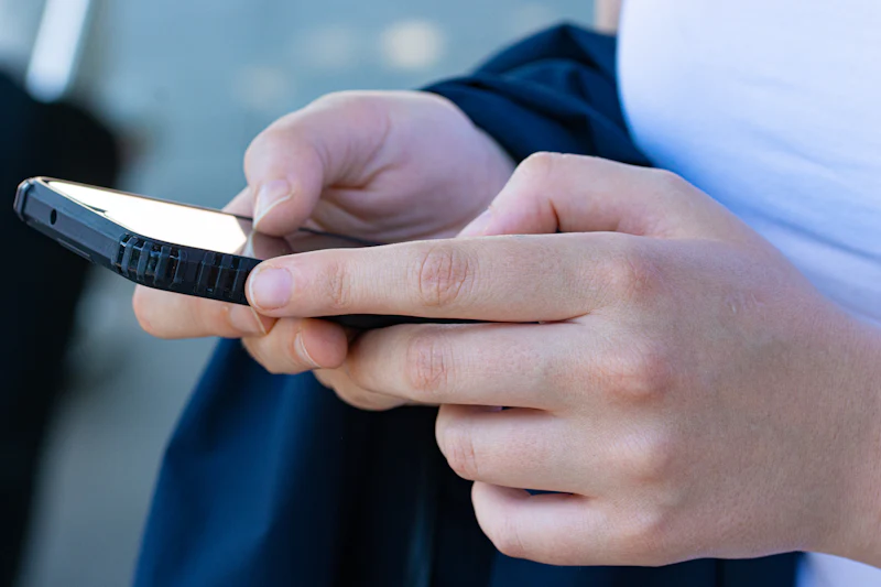 Personne au téléphone, gros plan sur les mains, lors d'un premier échange