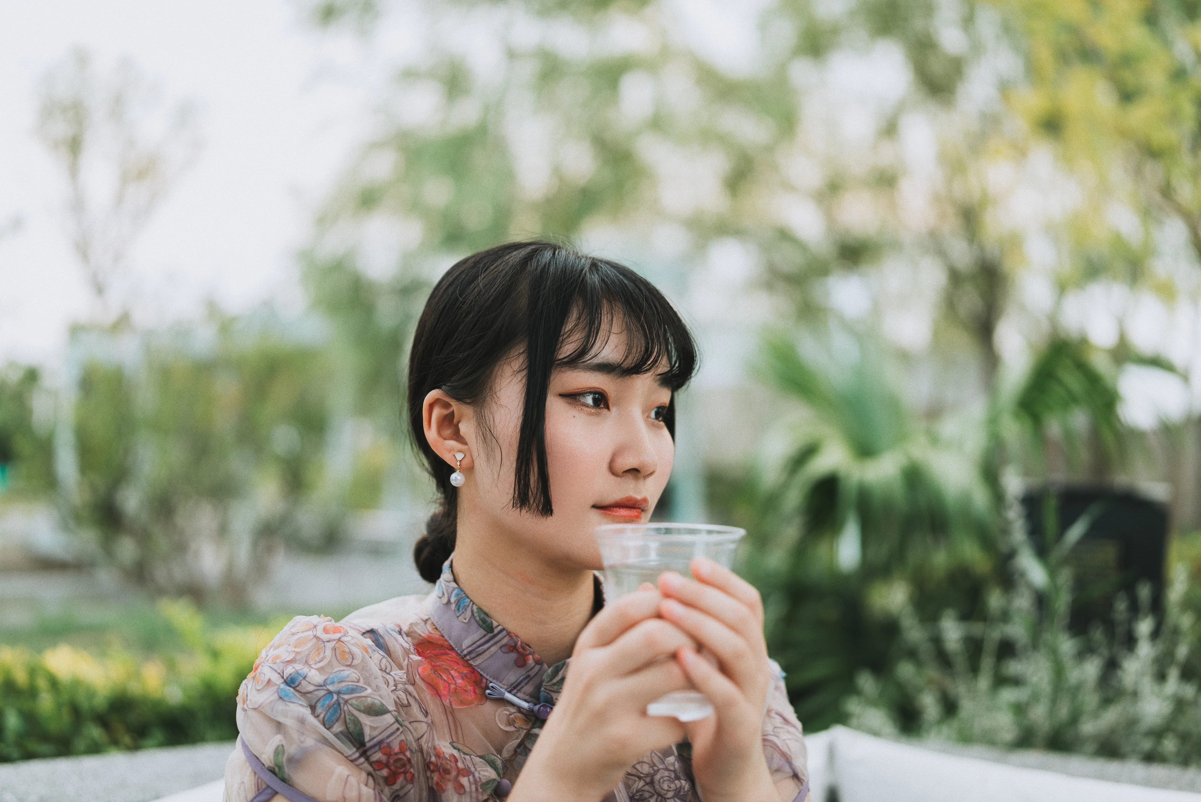 Woman holding a glass of water outdoors