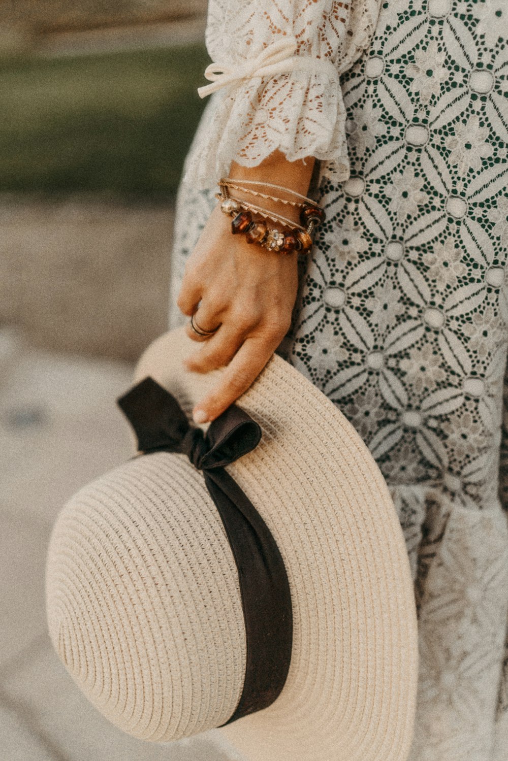 a person wearing a white dress and a black and gold bracelet