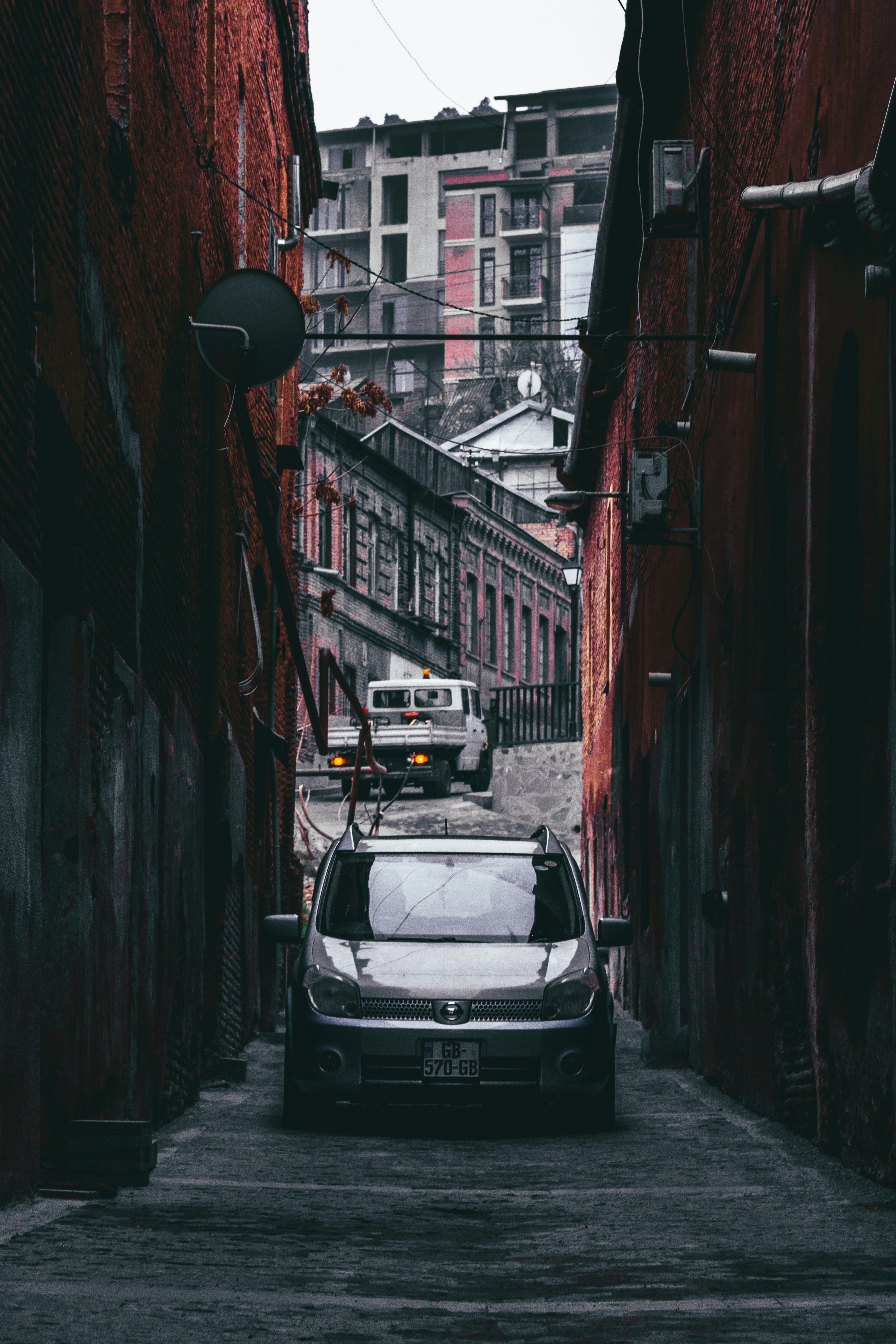 a car parked in a narrow alley between buildings