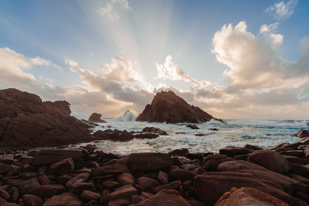 a rocky beach with a large body of water in the background