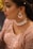 Close-up of a stylish woman wearing elegant jewelry and a designer dress.
