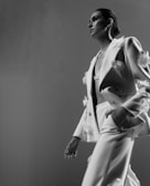 Model wearing a sleek, tailored formal suit with subtle floral patterns.