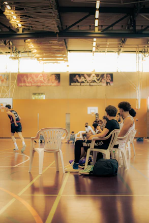 Dynamic shot of a basketball influencer filming a training drill in a high school gym.