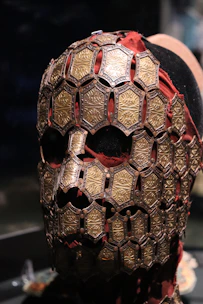 Close-up of handcrafted leather mask with subtle silver details on a dark background.