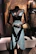 A sleek black leather corset set displayed on a mannequin with red leather accents.