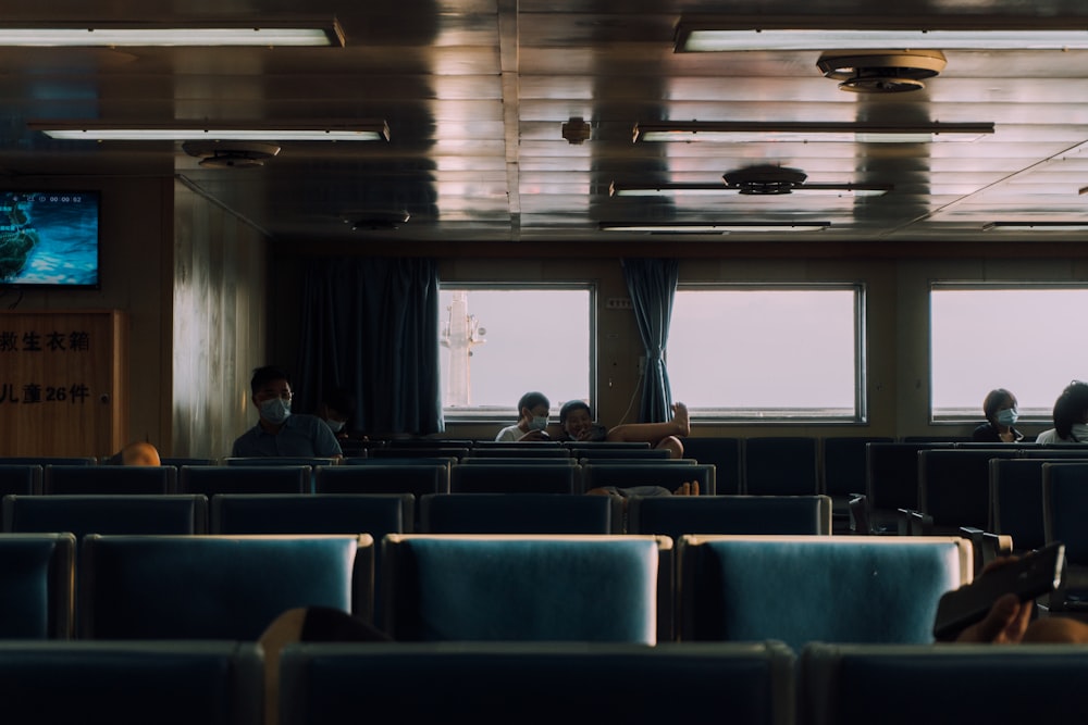 a group of people sitting in a room with a large screen