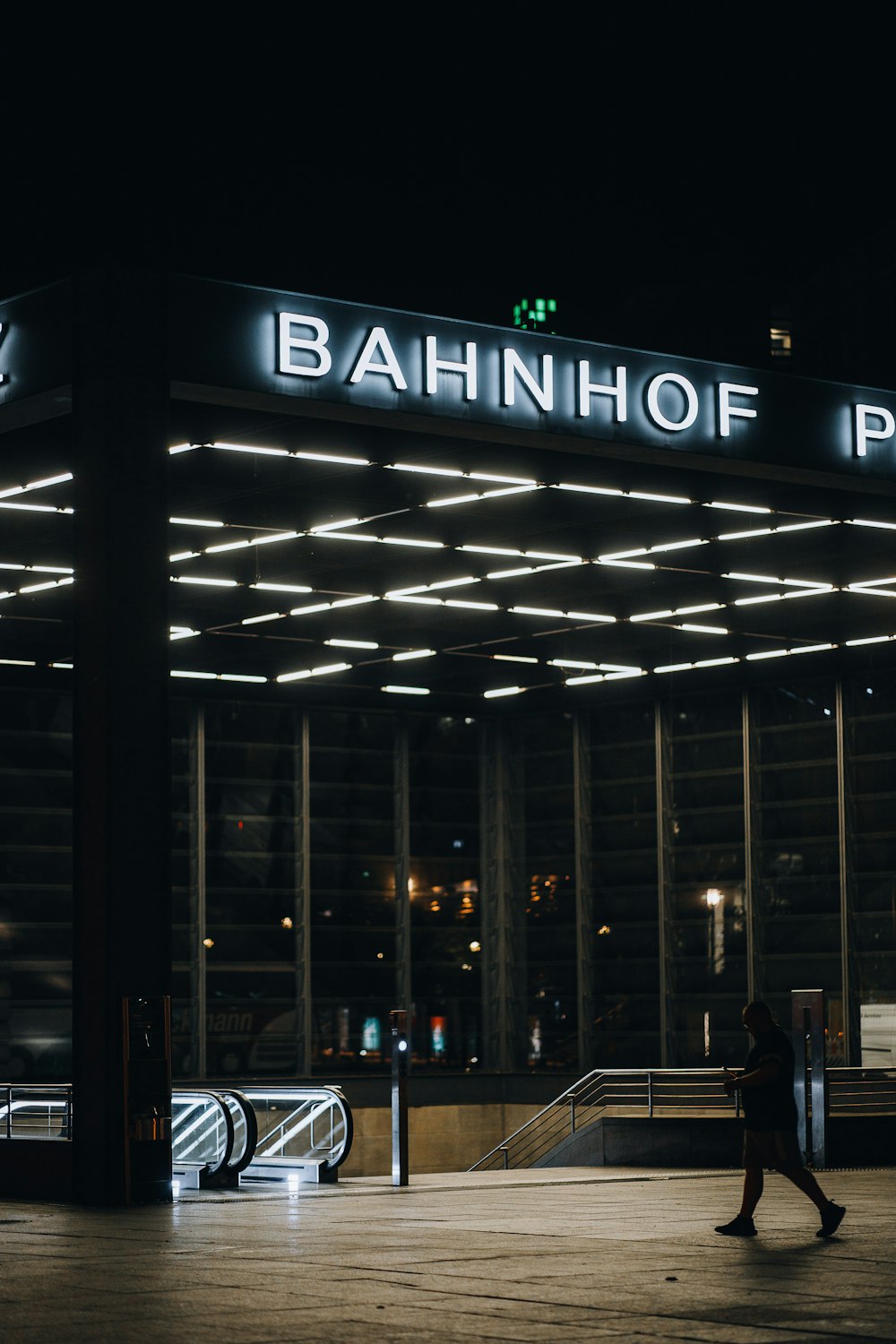 a person walking in front of a building with a sign on it