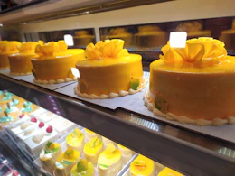 Happy customers receiving beautifully decorated cakes as repeat orders.