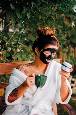 a person with a face paint holding a phone and a cup