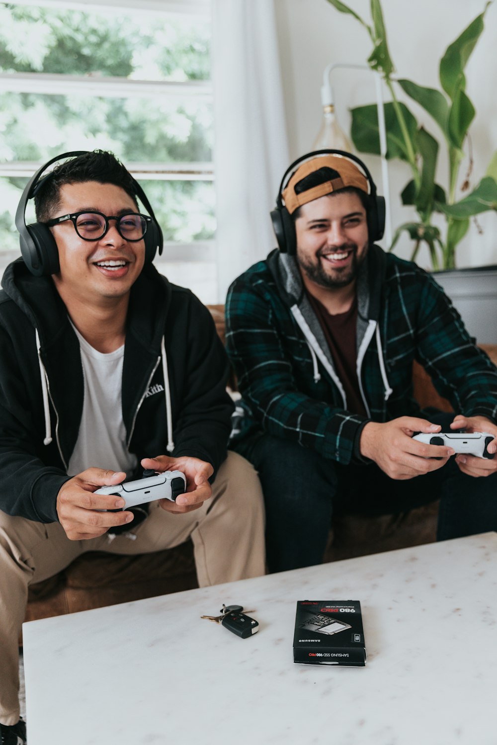 a couple of men sitting at a table with game controllers