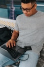 a man sitting on a bench with a laptop