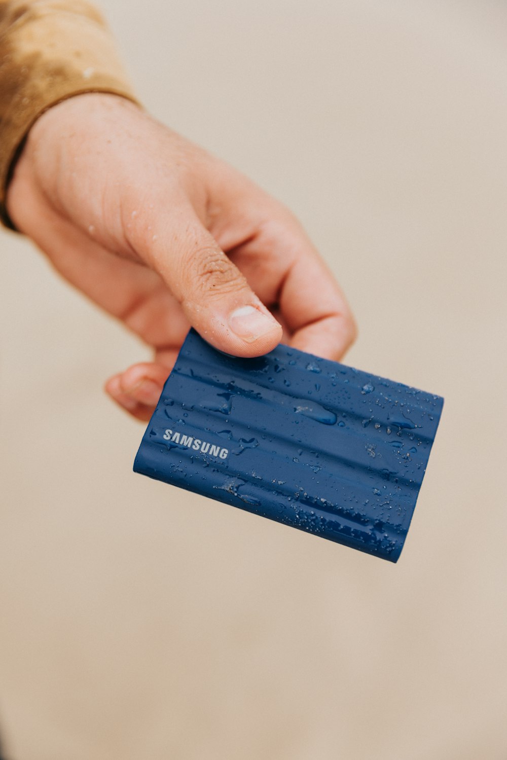 a hand holding a blue rectangular object