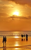 Happy travelers enjoying a beautiful sunset on a beach.