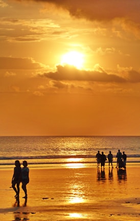Happy travelers enjoying a beautiful sunset on a beach.