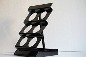 A close-up of a powder-coated metal display stand with a smooth matte black finish.