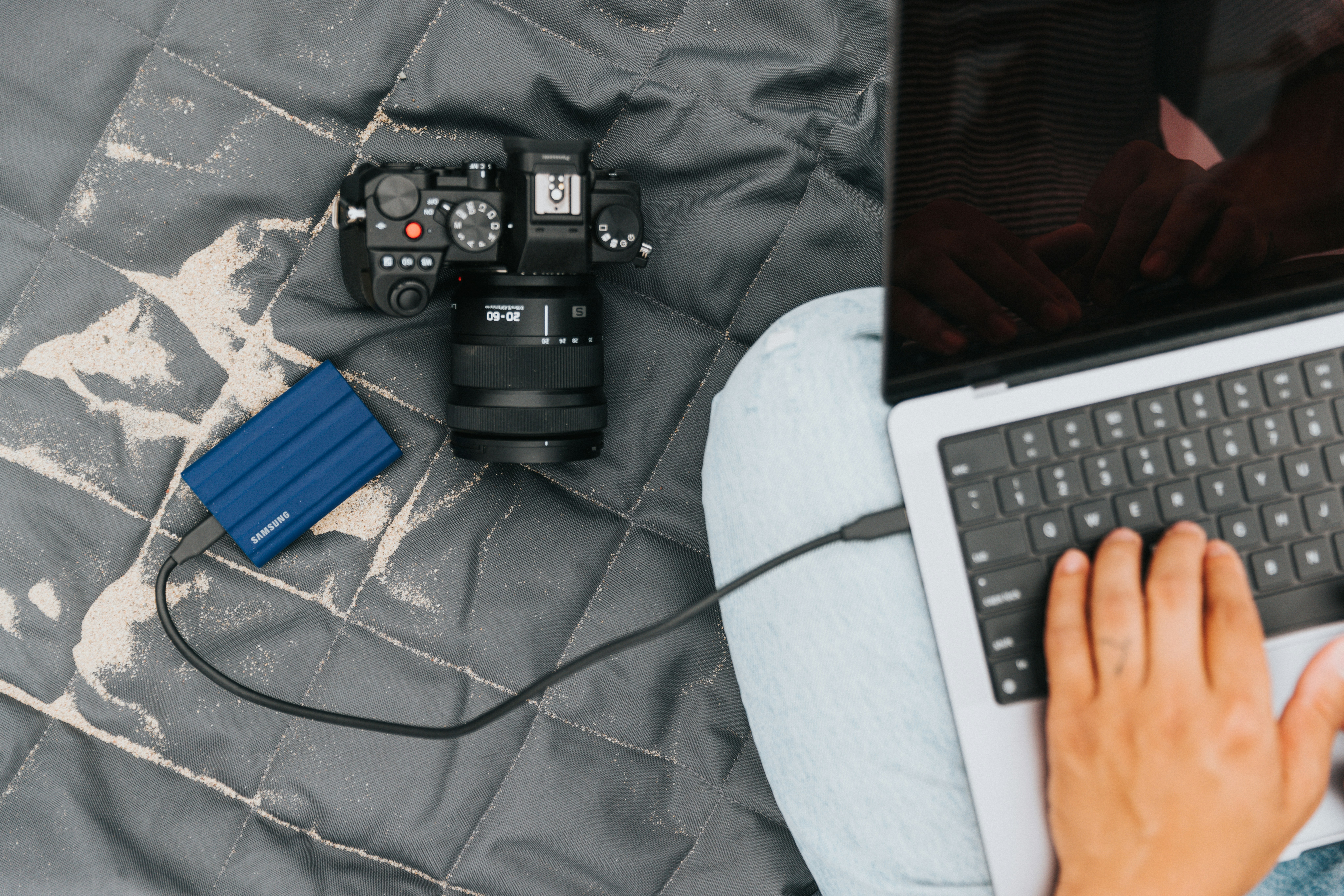 laptop and phone charging from a small inverter in the front seat of a car on a road trip