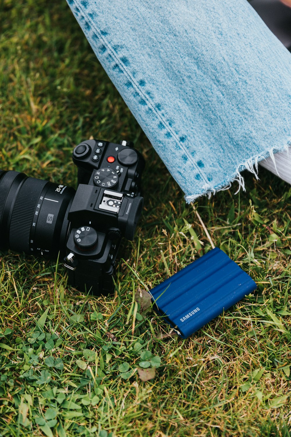 a camera and a book on the grass