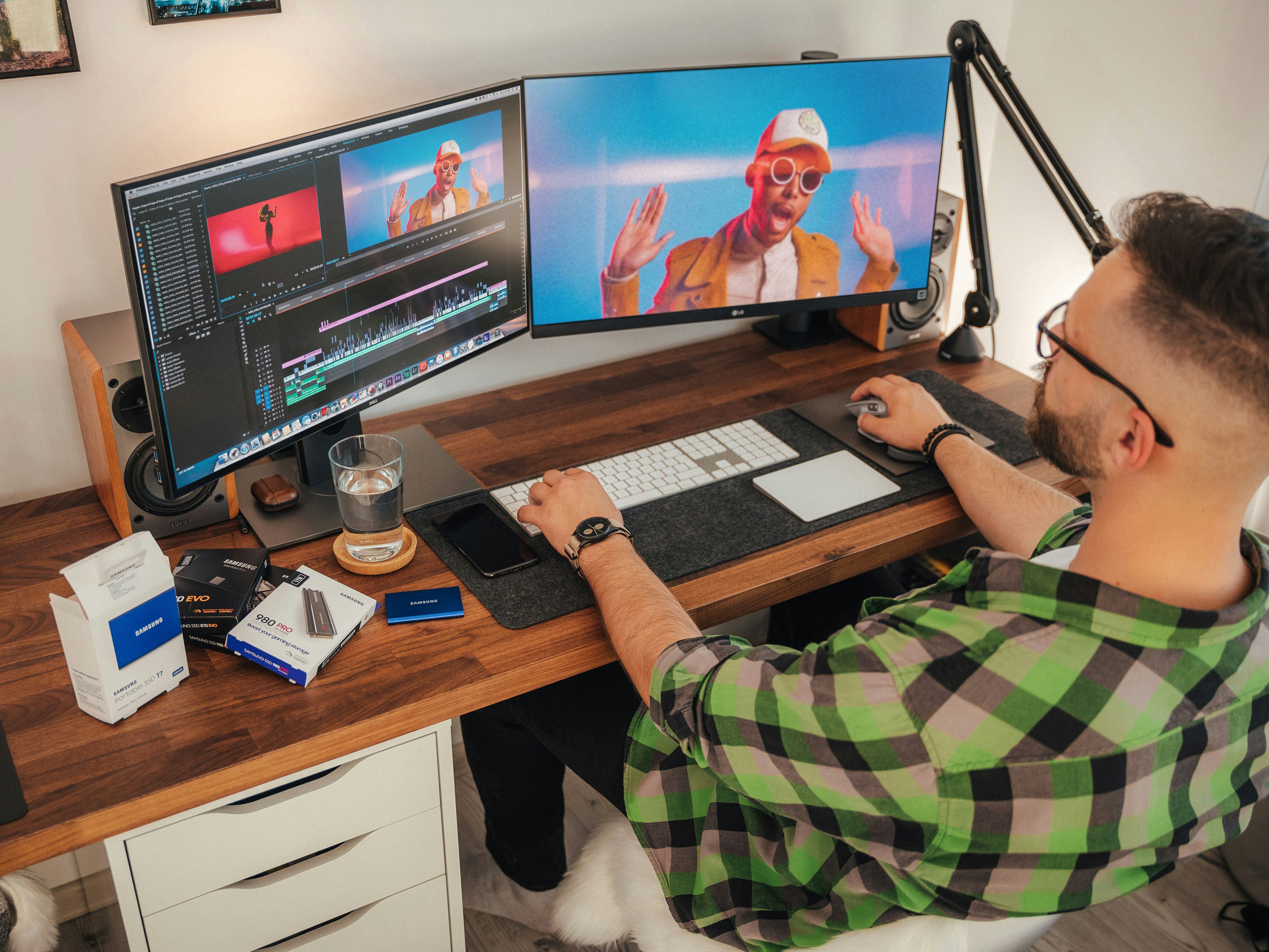 Um homem sentado em uma mesa com dois monitores