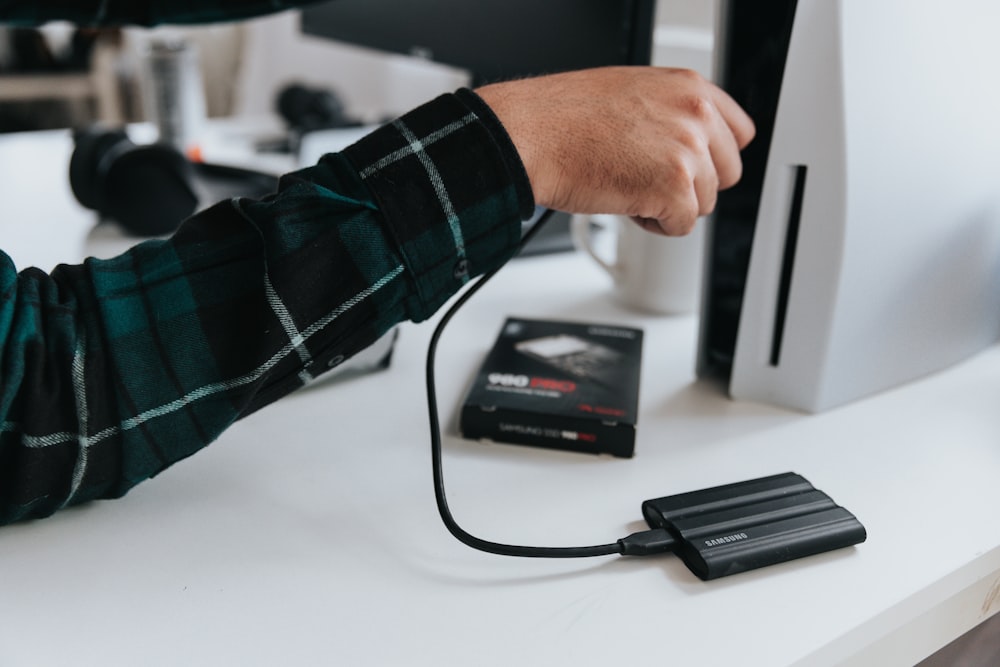 a hand holding a black device