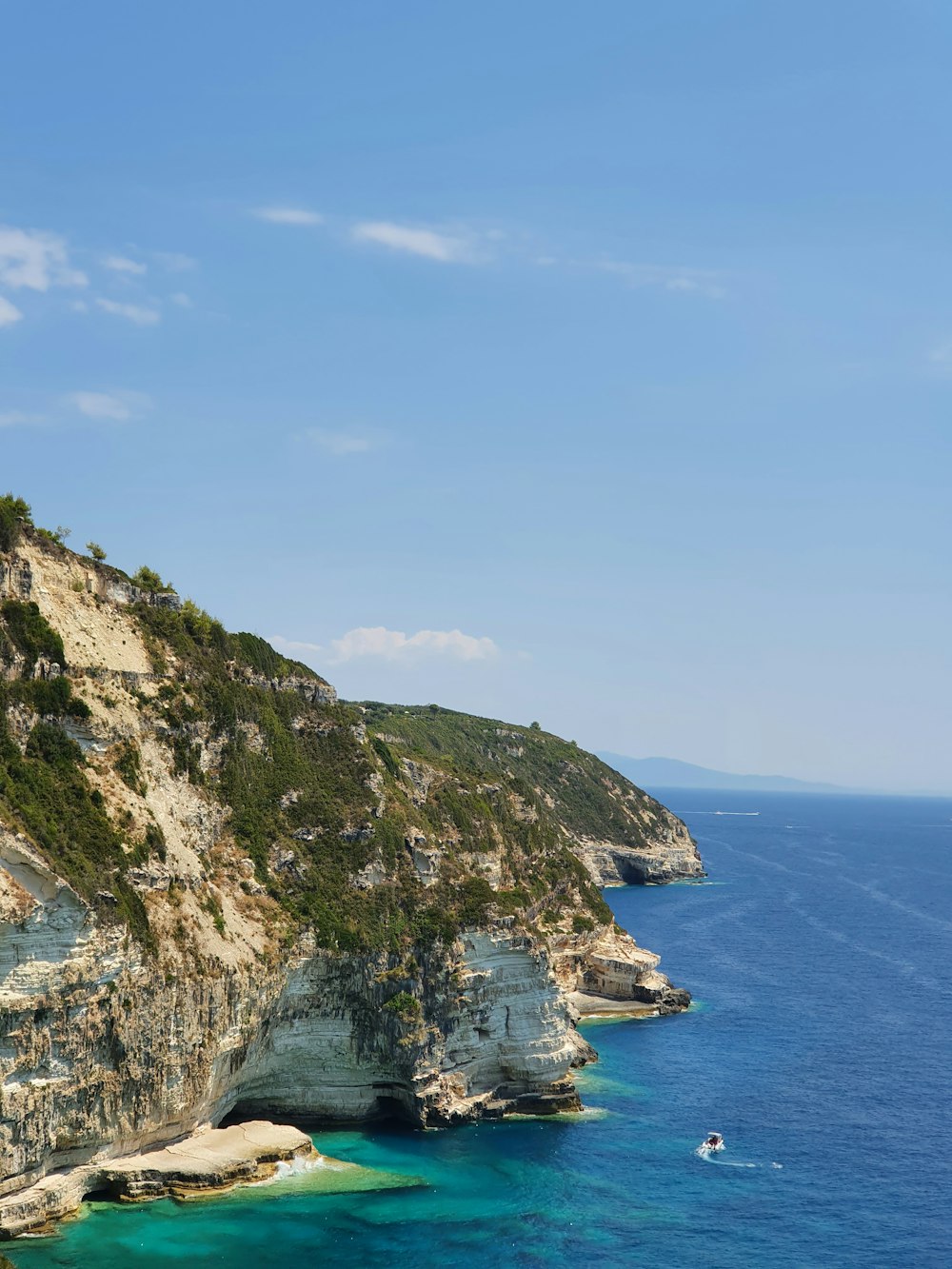 a rocky cliff with a body of water below