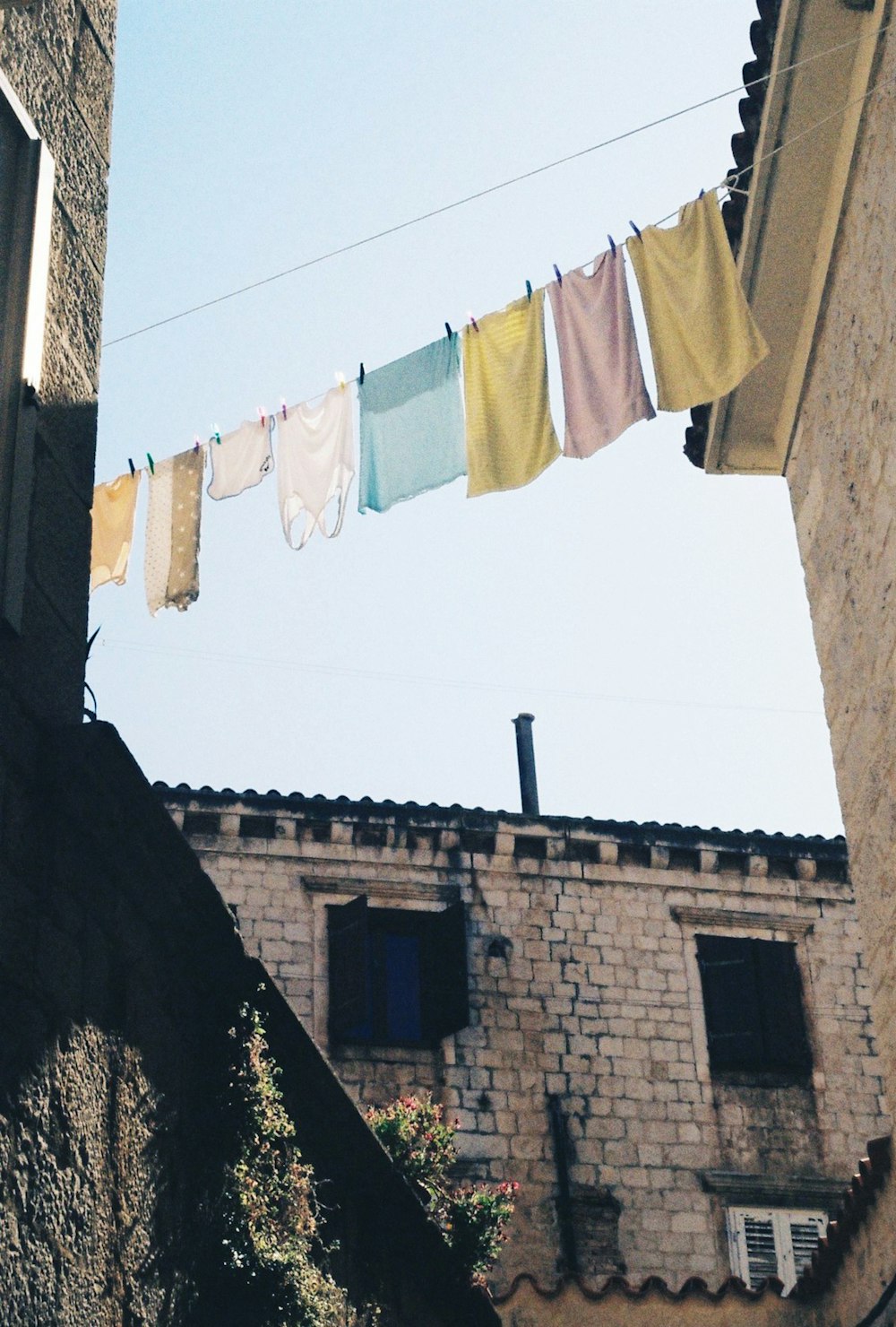 a line of clothes on a line outside of a building