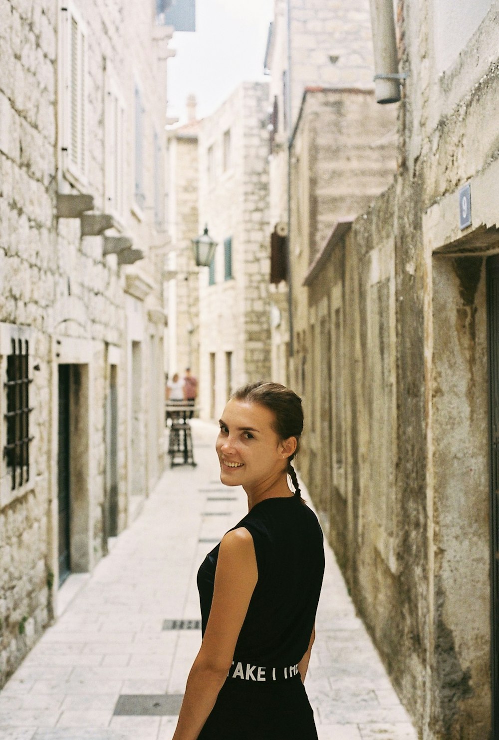 a woman standing in a narrow alley